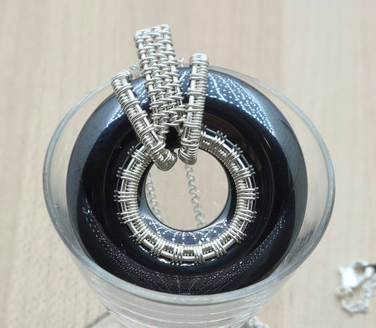 Shiny hematite donut with woven wire silver plated bail
