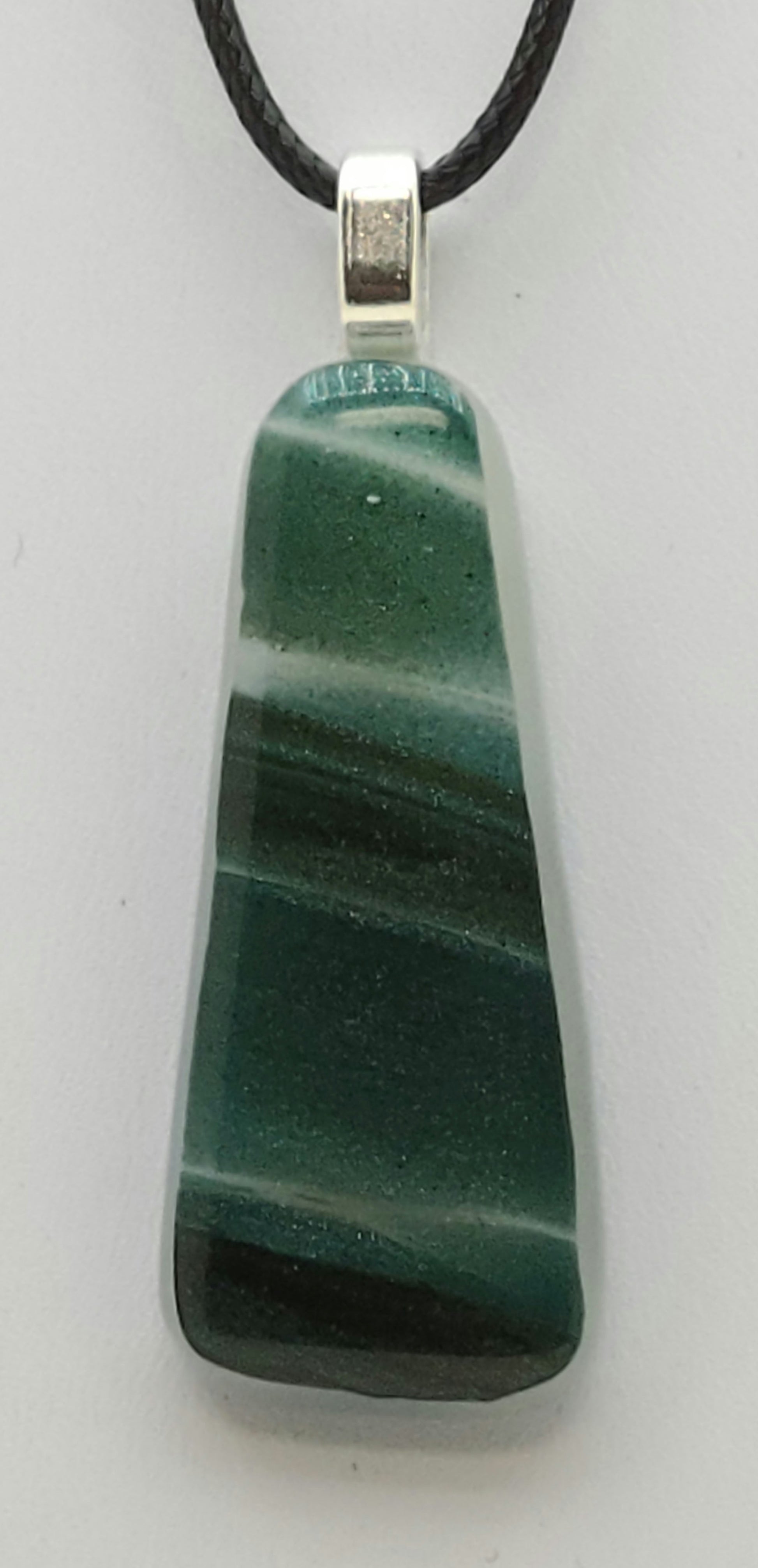 sparkling swaths of green cross this slender fused glass pendant.