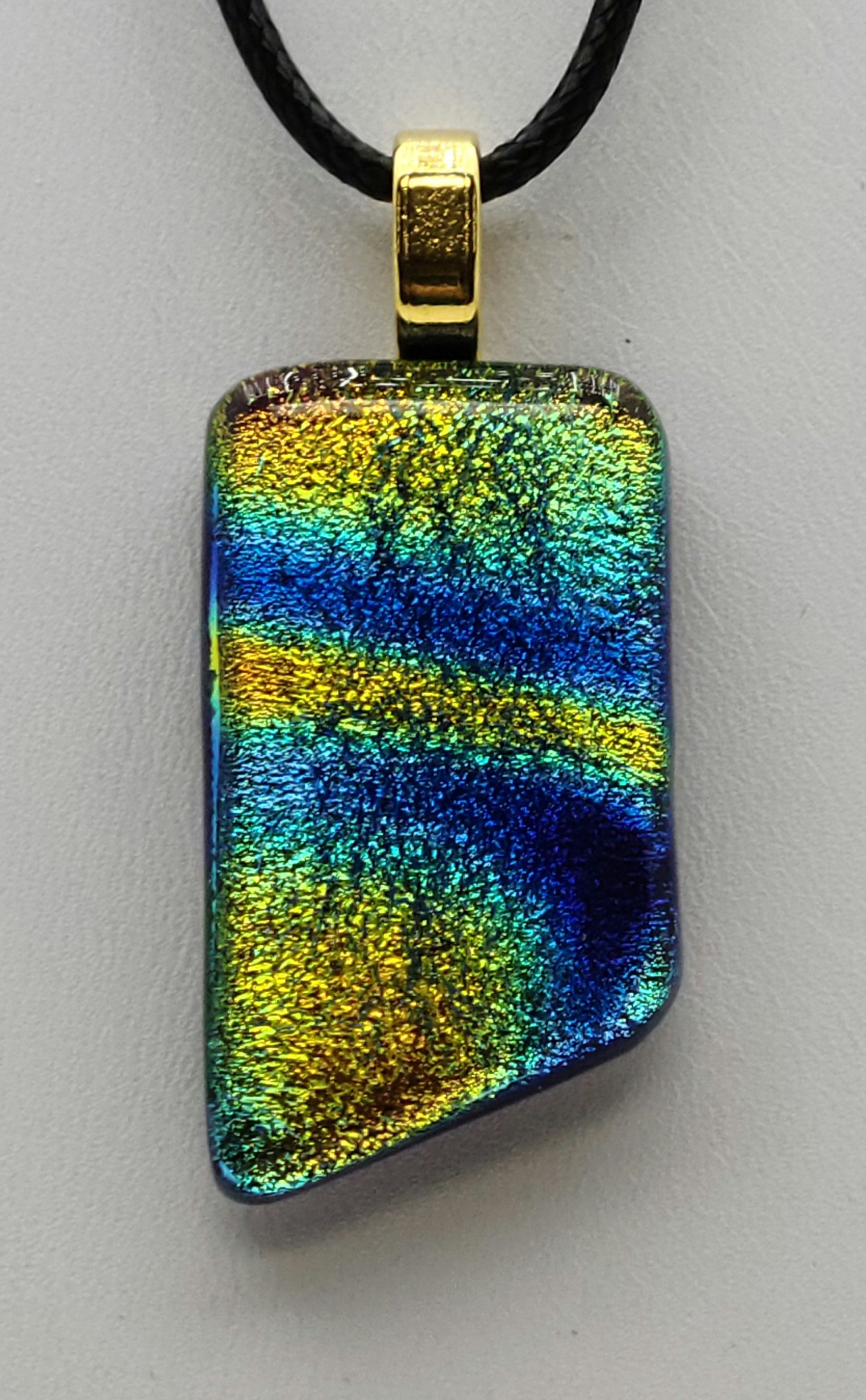 This dichroic fused glass pendant resembles an early forming sky!