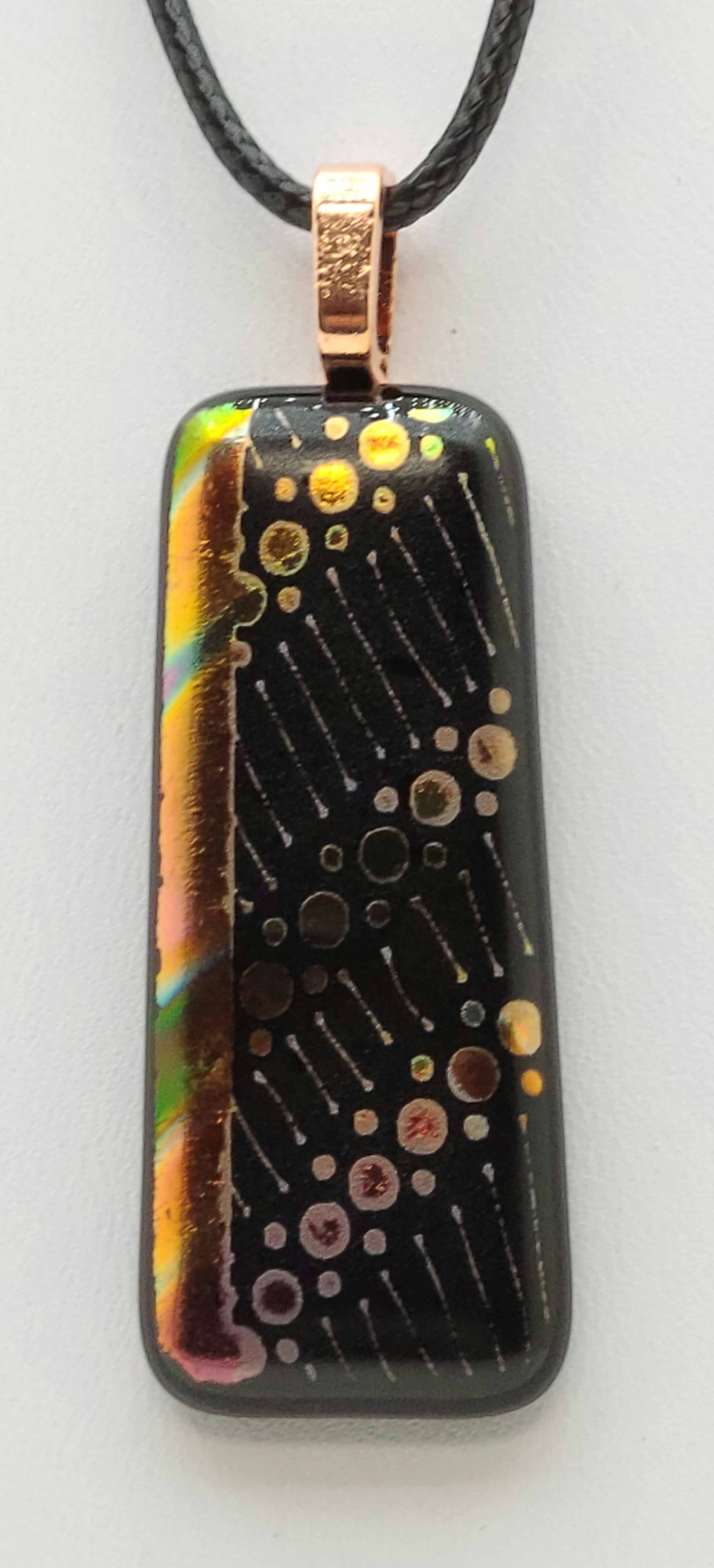 Dots of various colors float across this dichroic fused glass pendant.
