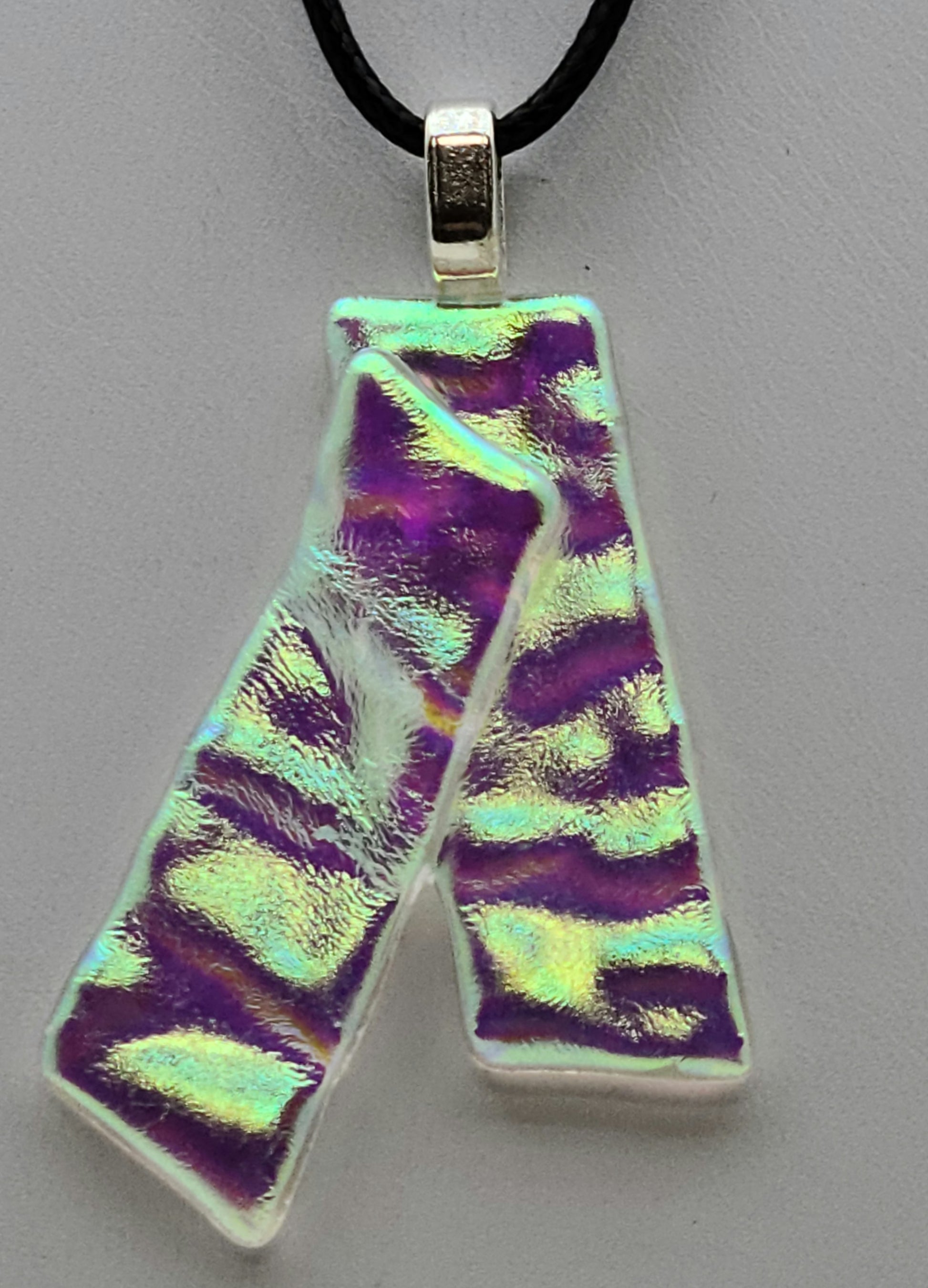 These dichroic glass ribbons with let a bit of the colors you're wearing influence the color of the pedant.