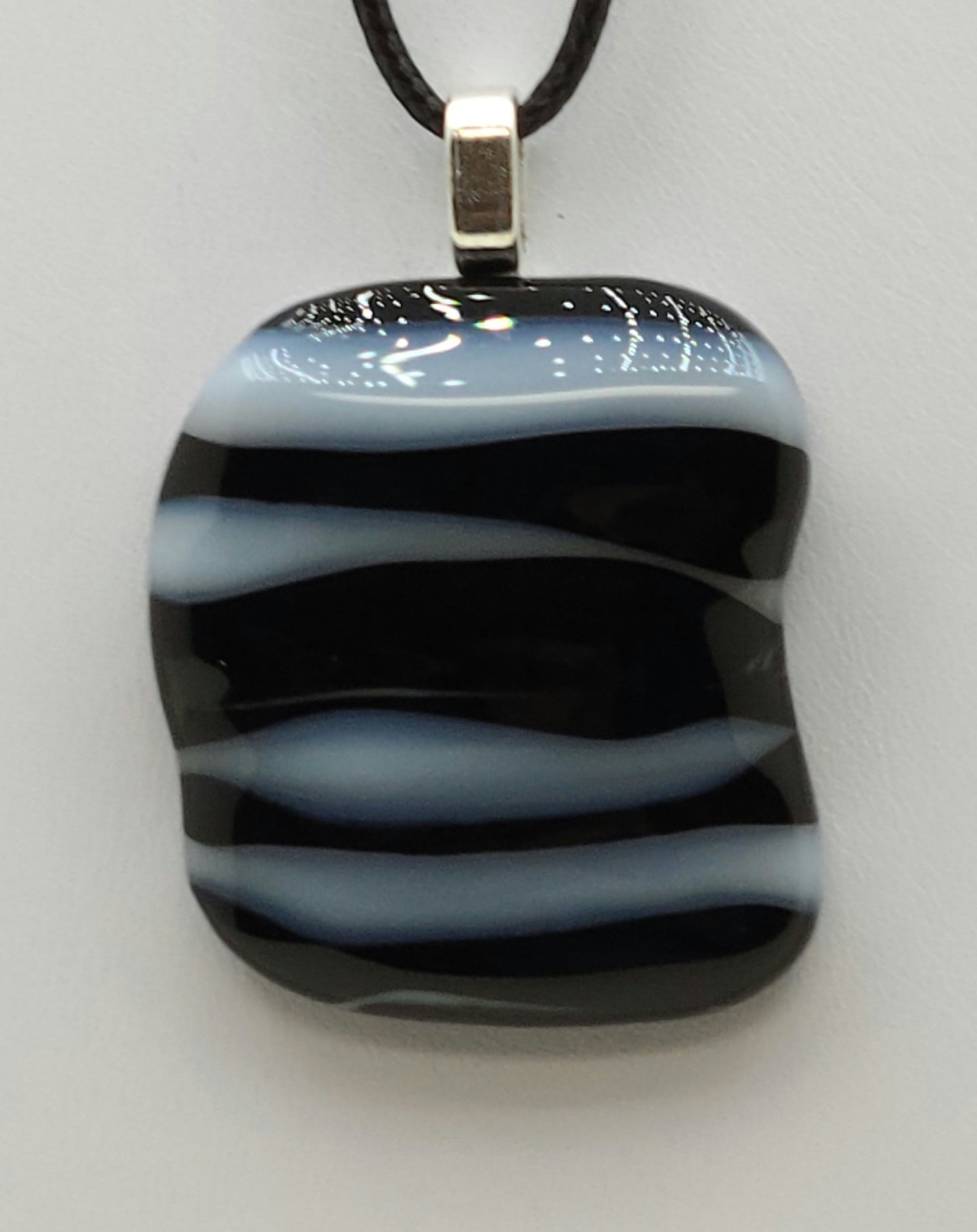 A lovely, lumpy black & white layered fused glass pendant.