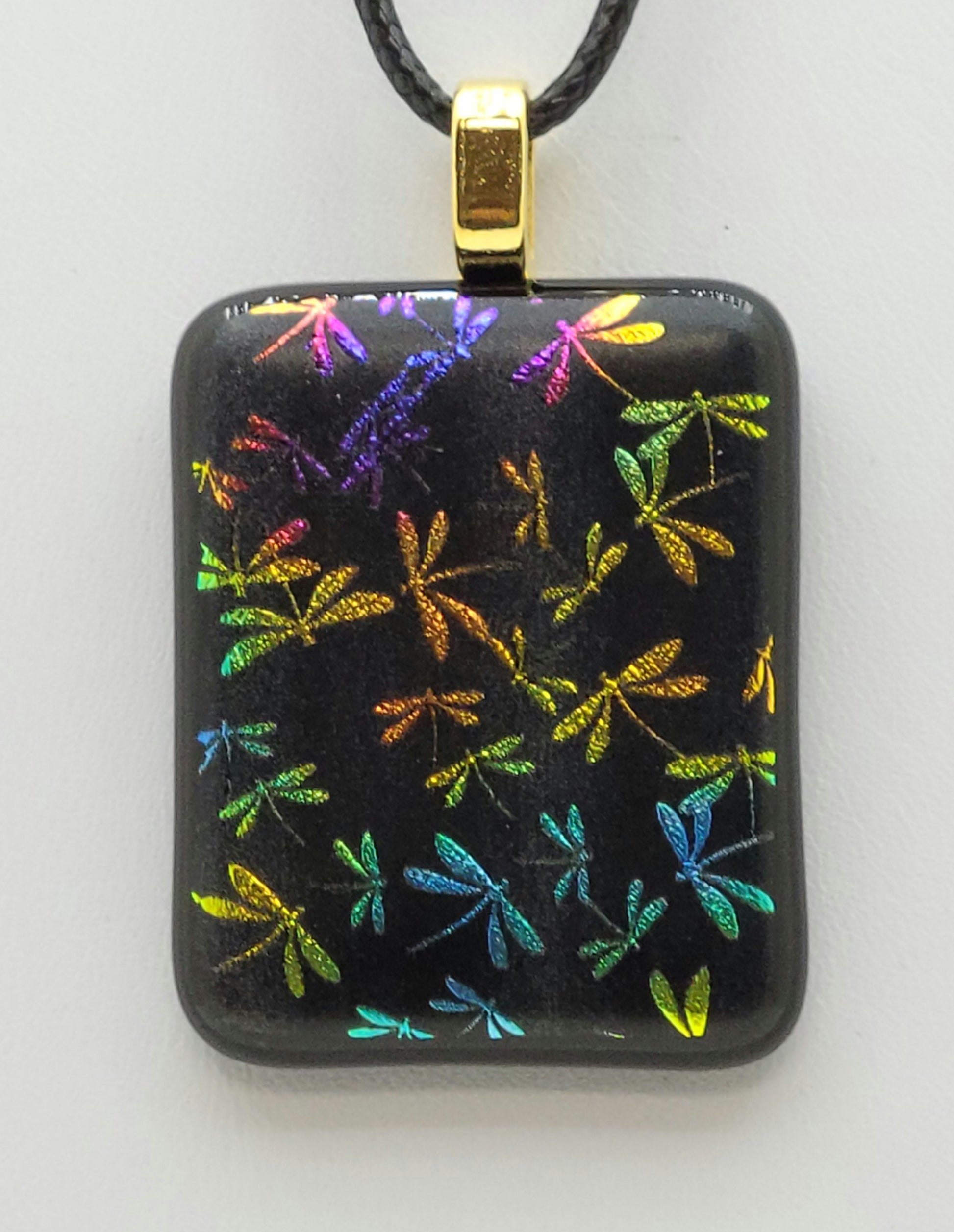 colorful dragonflies are etched into this dichroic fused glass pendant