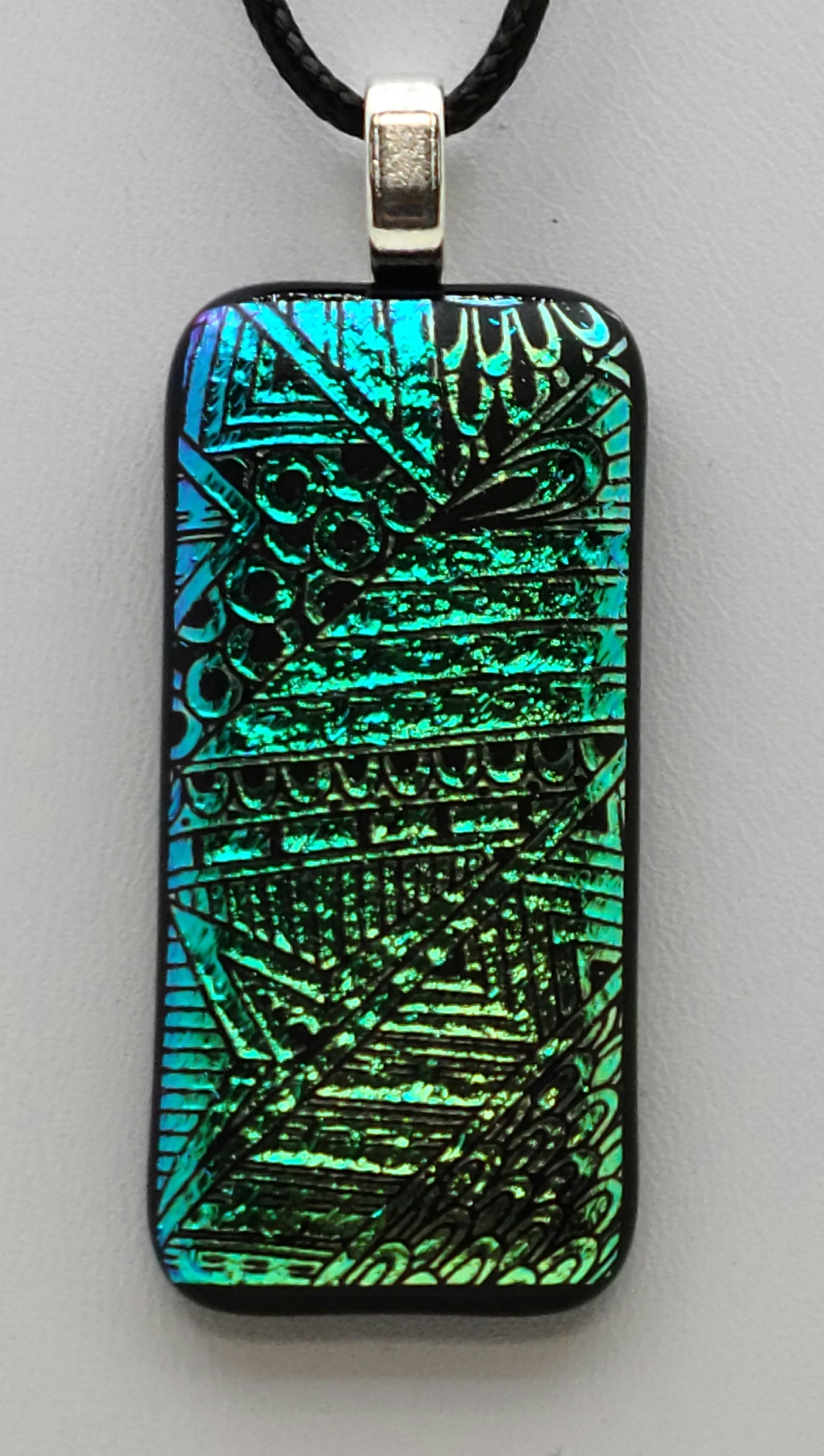 Geometrics abound in this crinkle, etched dichroic fused glass pendant