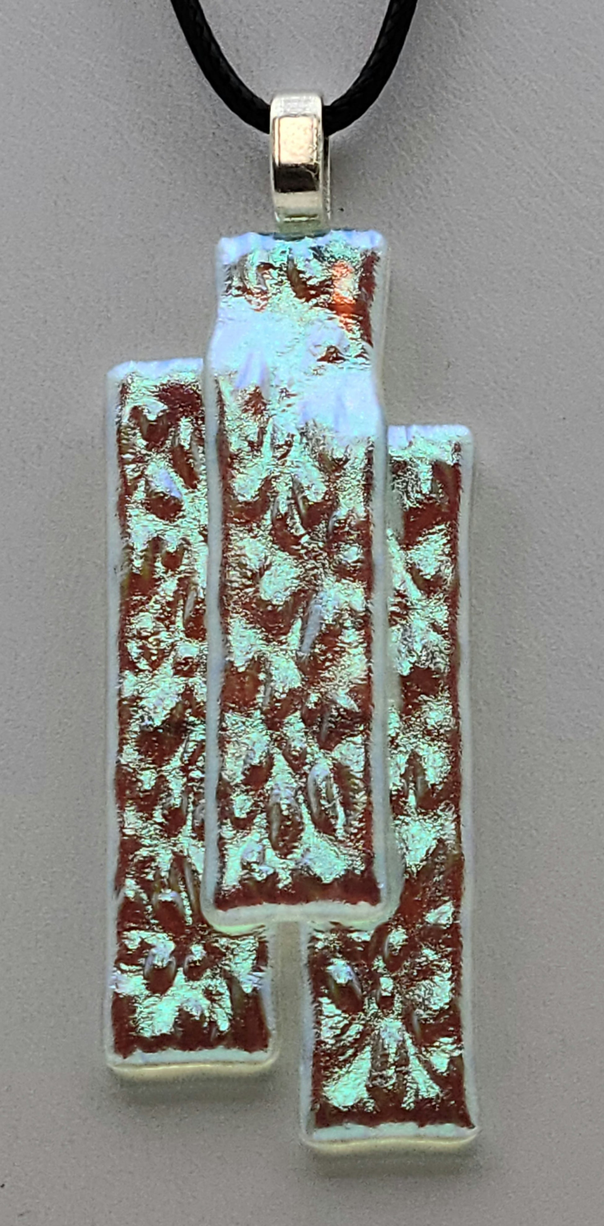 This stacked dichroic fused glass pendant will take on the hue of the underlying clothing!