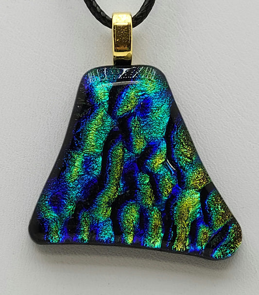 This dichroic fused glass pendant features teal, gold, & turquoise ripples.