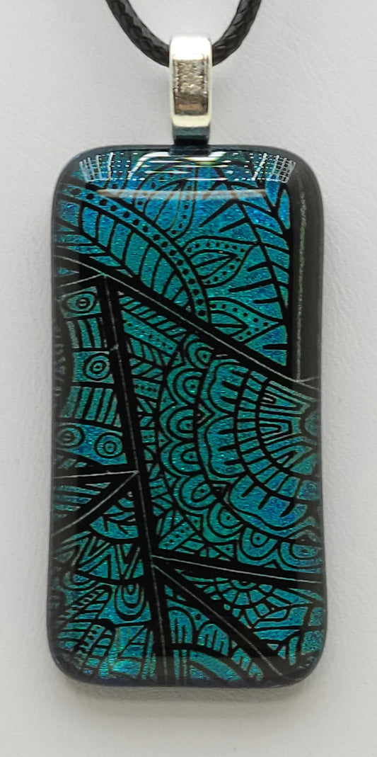 This clear capped dichroic fused glass pendant showcases stained glass window designs in teal.