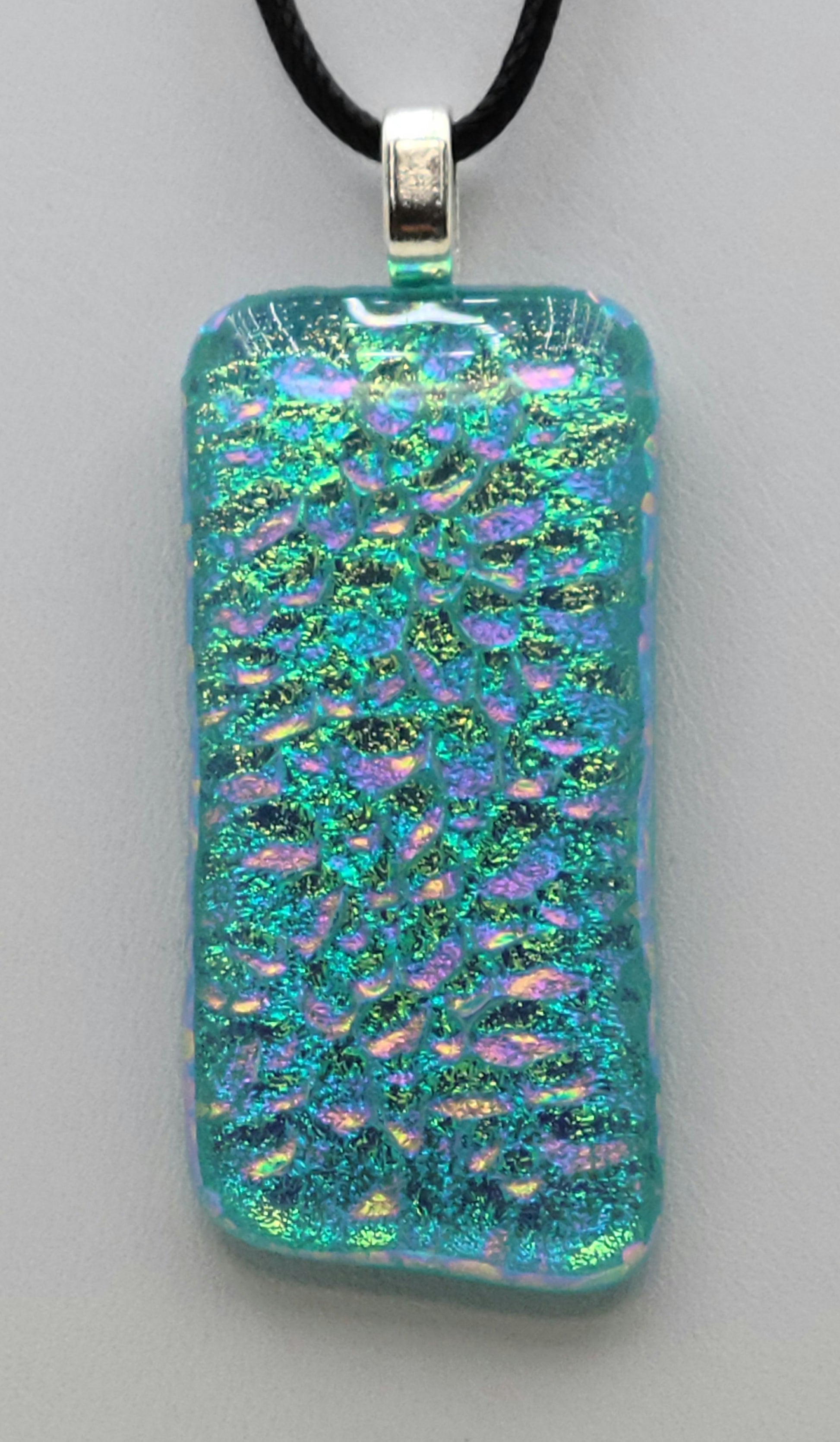 Blingy bubbles float in this aqua dichroic glass pendant.