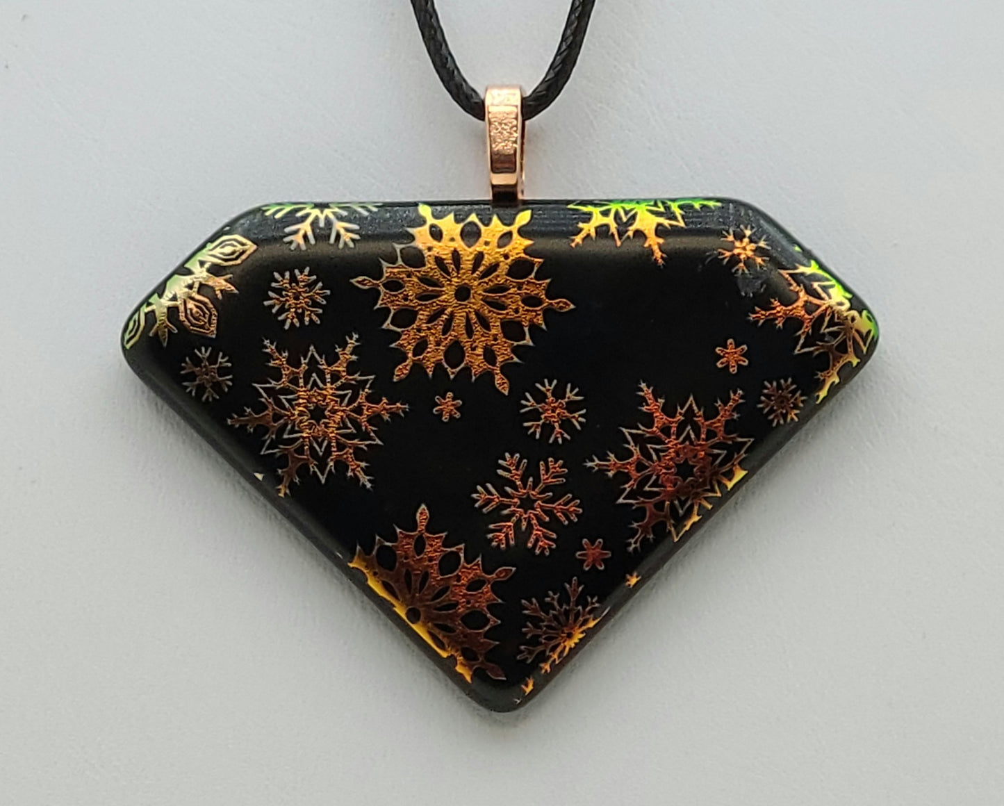 It's snowing coppery, unique snow flakes in this etched dichroic fused glass pendant.