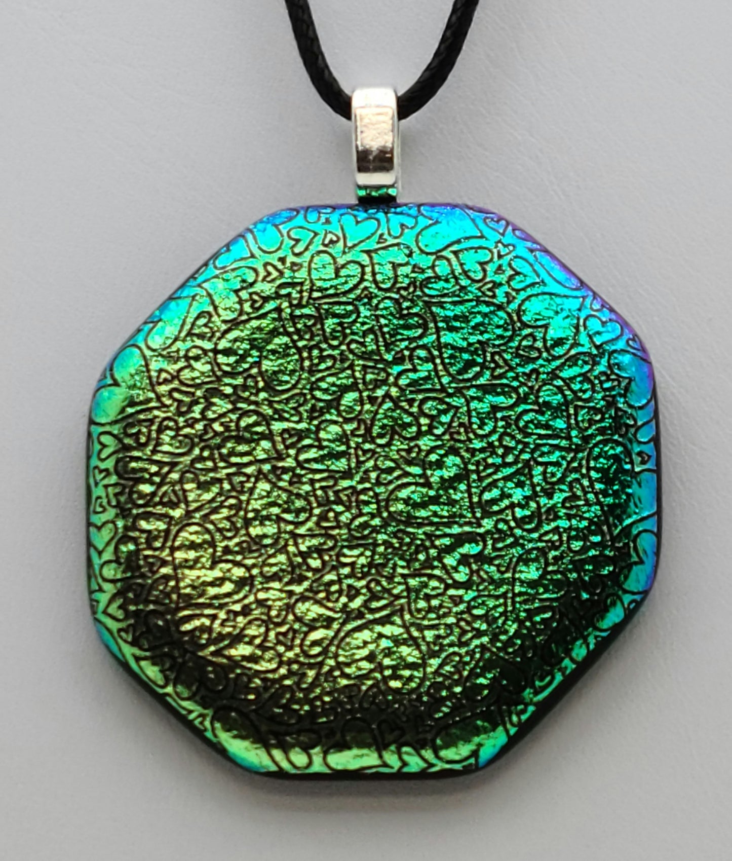 tiny random hearts are etched into this green crinkle dichroic fused glass pendant.