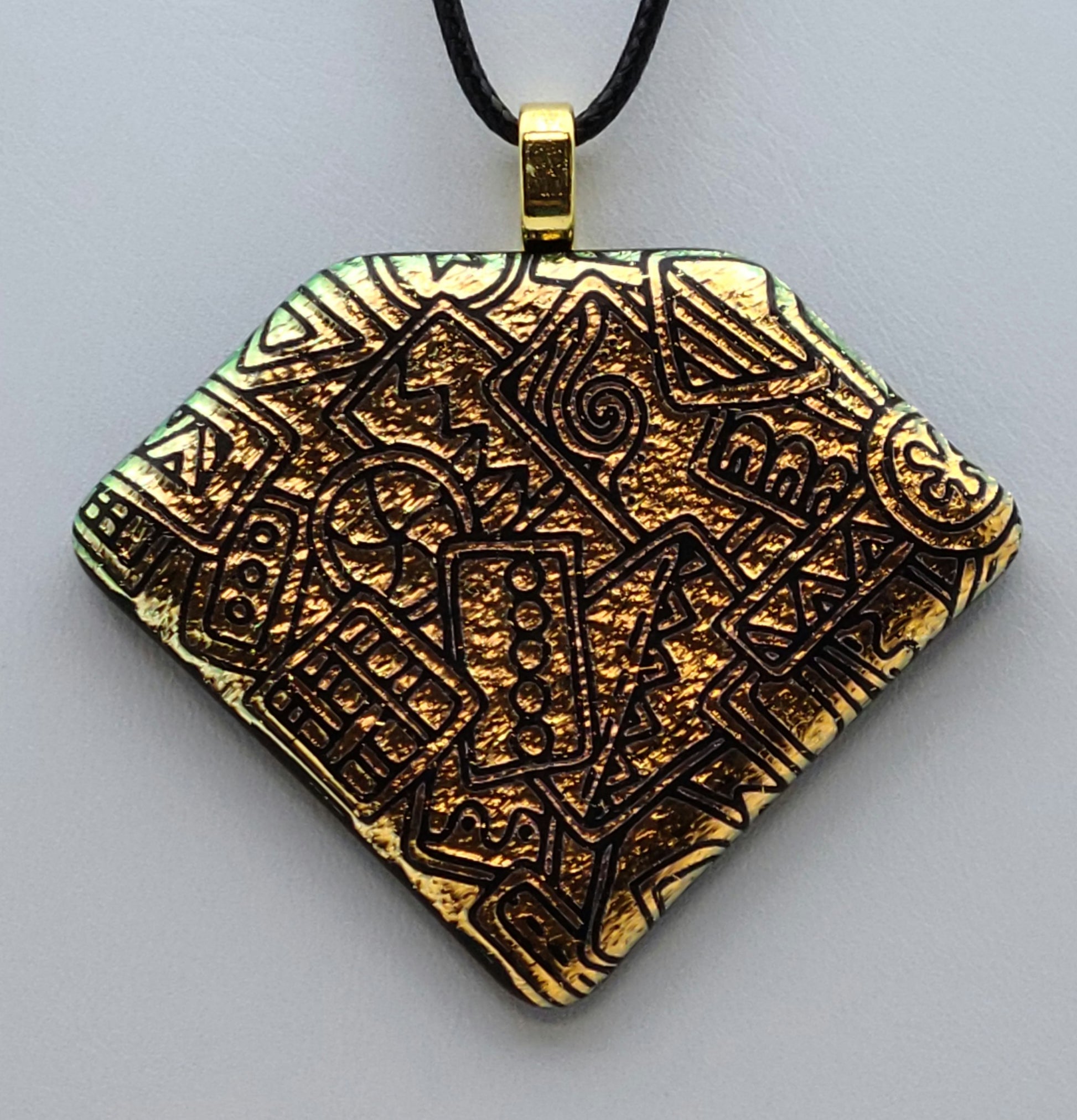 Bright gold crinkle dichroic glass has been etched with various geometric designs in the lovely fused glass pendant.