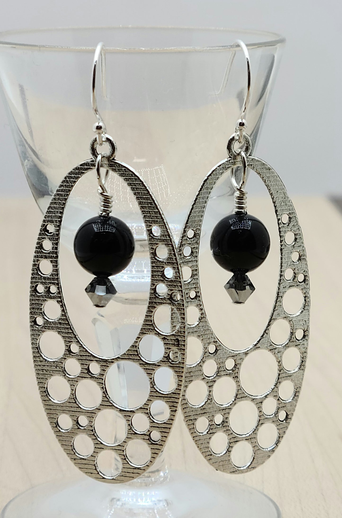 These pewter oval 'holey' hoops are such fun! Black crystal pearls with chrome crystal accents add color &amp; movement!