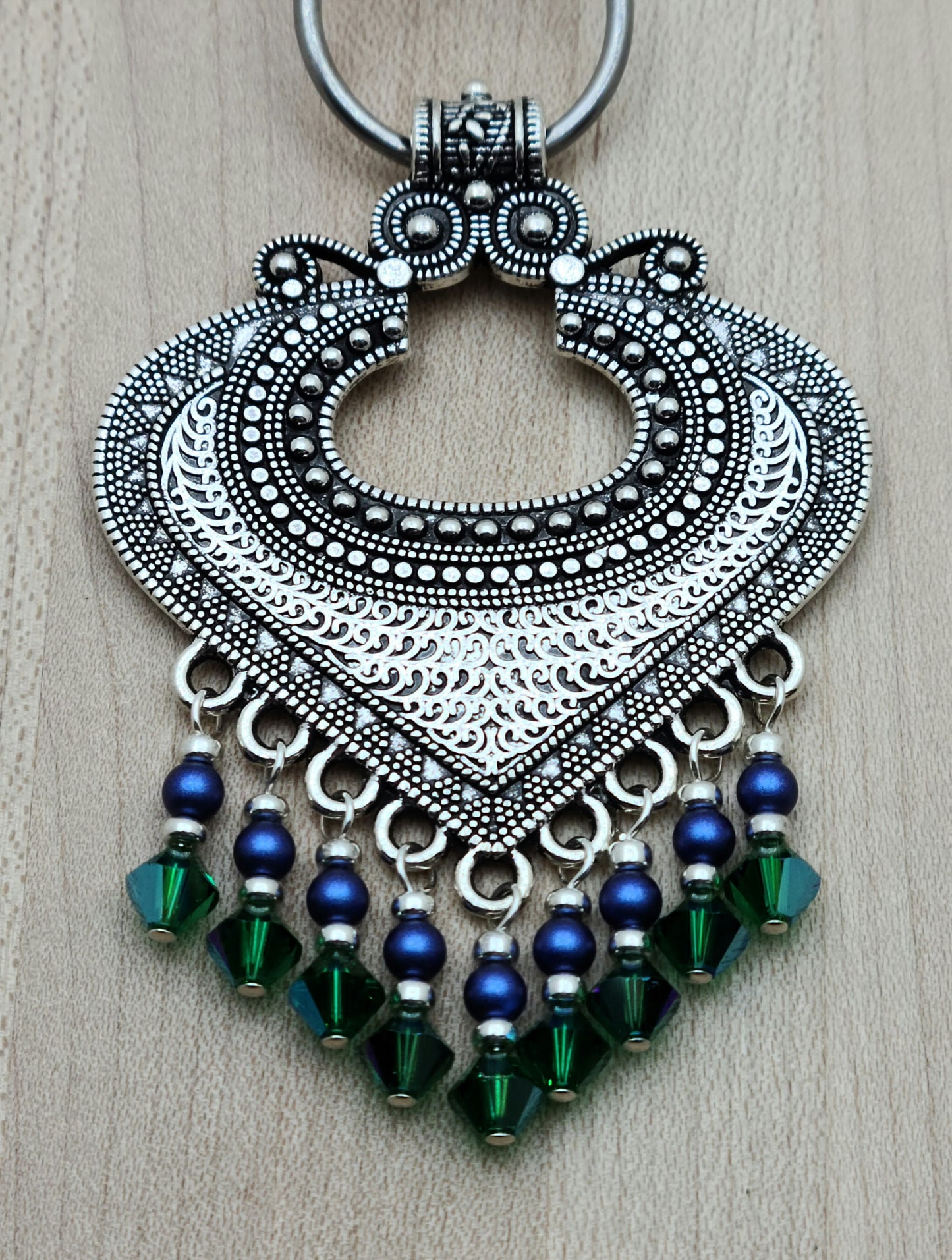 large pewter bali style pendant with bright blue and rich green dangles 