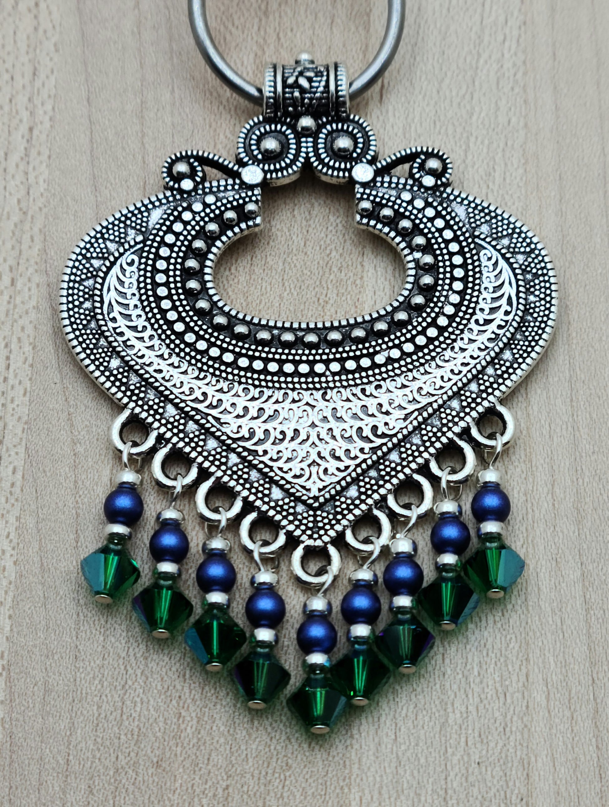 large pewter bali style pendant with bright blue and rich green dangles 