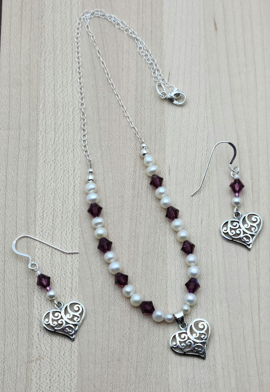 This sophisticated & sweet set features luminous white freshwater pearls & vibrant amethyst crystals, accented by a delicate filigree sterling silver heart pendant with matching earrings