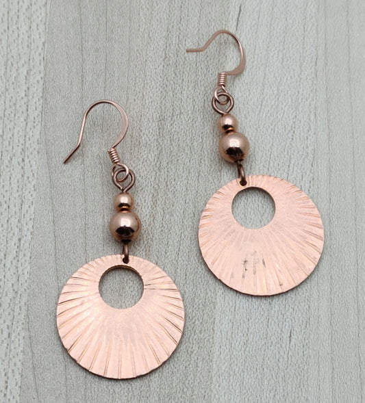 Bring sunshine to your style with Bright Copper Sunburst Earrings. The radiant copper disks capture the essence of a sunburst, adding a lively glow to your look. 