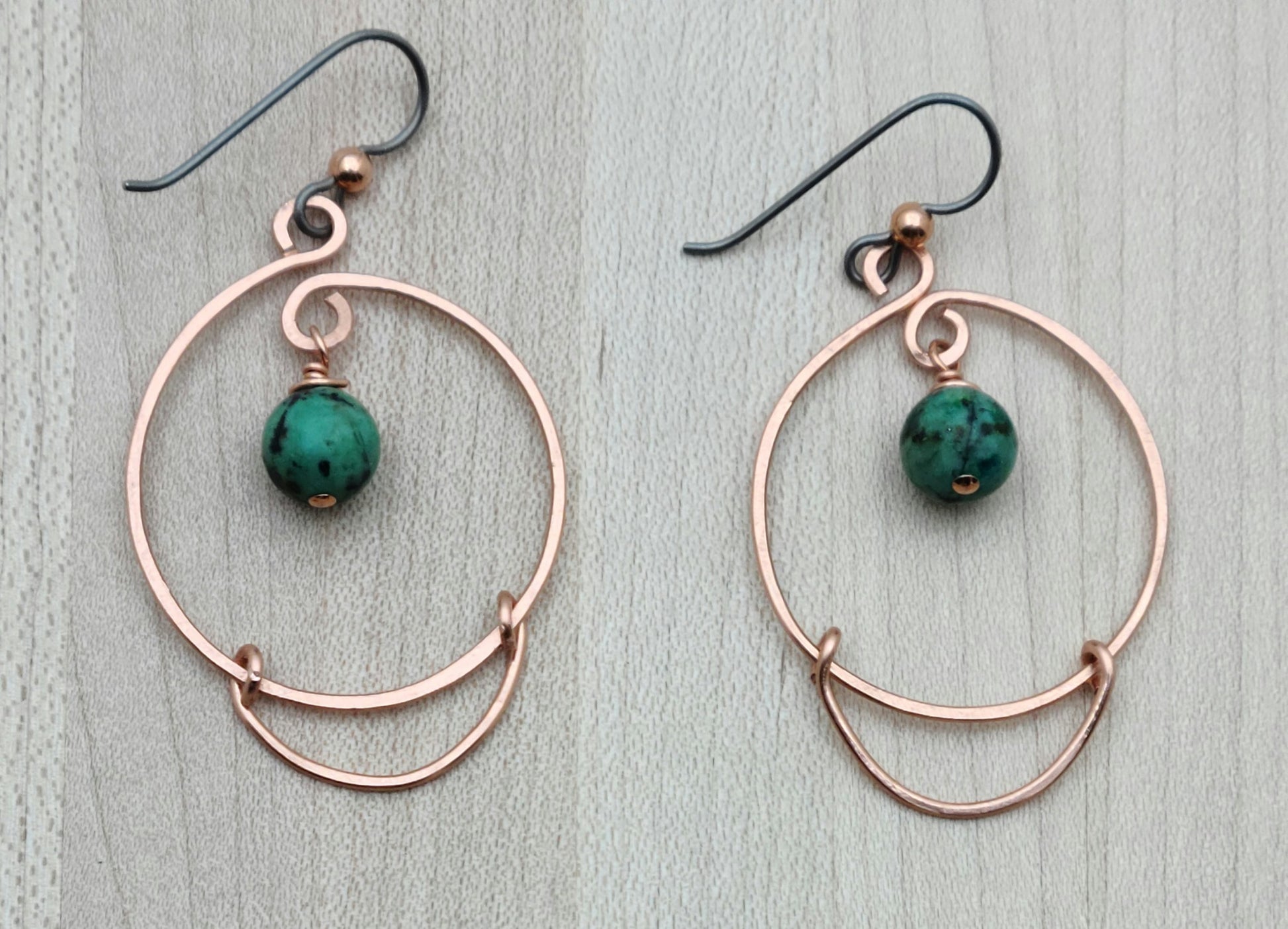 These hammered copper hoops add a playful twist with genuine African turquoise stones, bringing a splash of color to your ears.