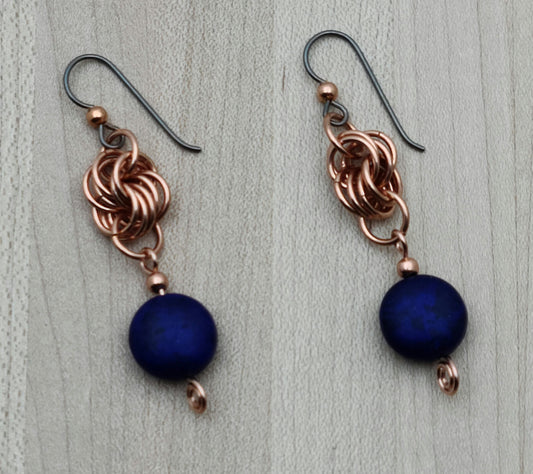 These Copper & Blue Coin Earrings bring a playful twist to your accessory collection. Navy blue coin-shaped stones dangle cheerfully from intertwined copper rings, adding movement and eye-catching color. Hypoallergenic niobium French hook ear wires ensure comfortable wear for sensitive ears, making these earrings a fun and worry-free choice.
