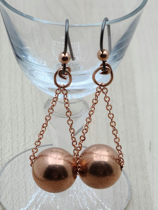 Add a pop of shine and fun to your look with these Copper Globes Earrings. Featuring large, bright copper balls that dance and catch the light, they hang effortlessly from delicate chains and copper wire. Finished with hypoallergenic niobium ear wires, they’re perfect for sensitive ears and guaranteed to spark smiles wherever you go.