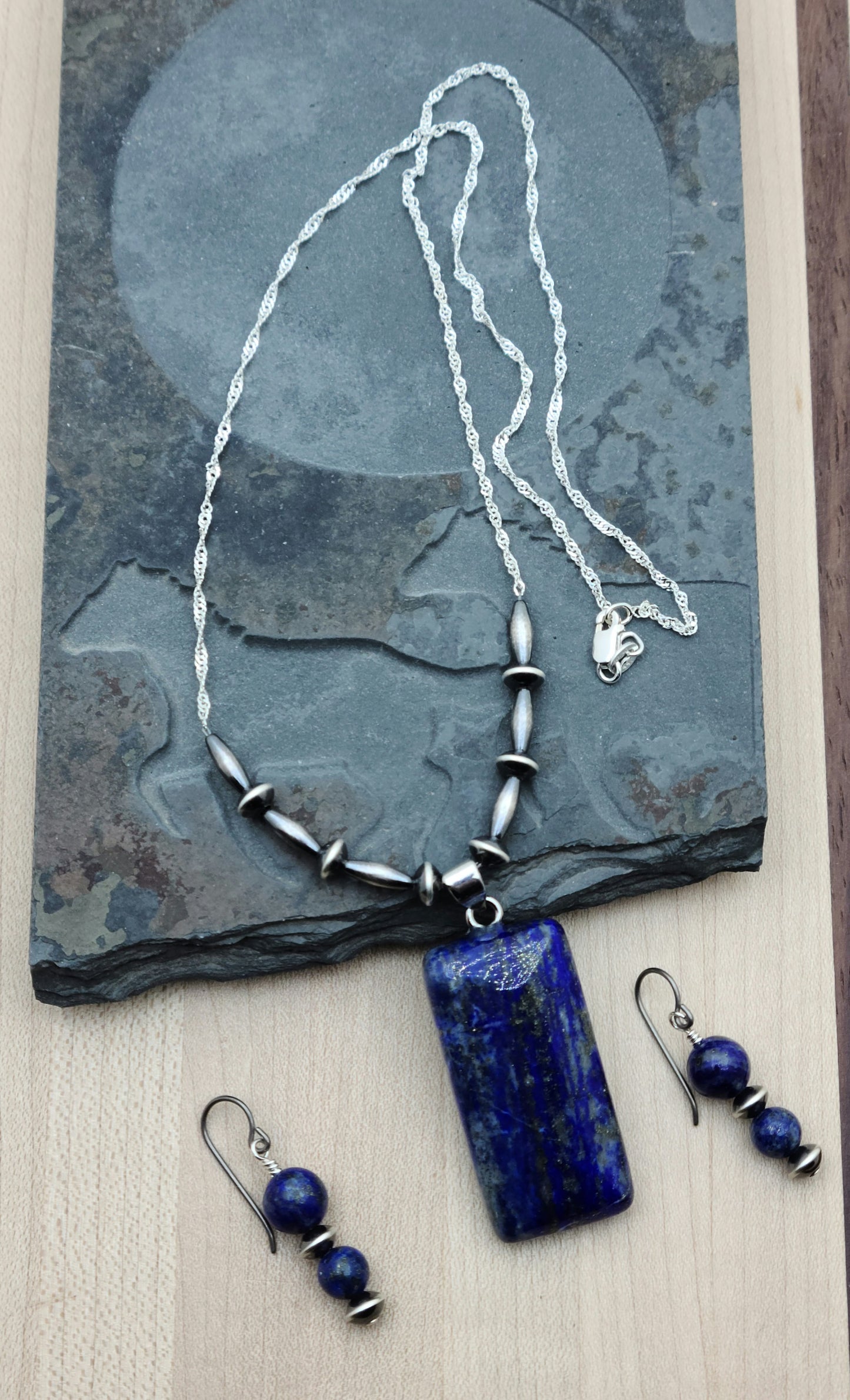 Lapis lazuli is a beautiful stone, prized for its deep blue color. It is said to promote wisdom & self-awareness. Navajo style silver is a lovely, often oxidized sterling silver. They create a lovely necklace and earring set here!
