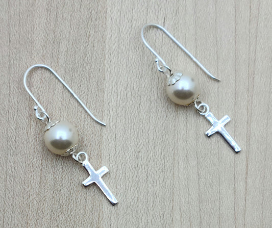 Dainty sterling silver cross dangle from creamrose crystal pearls on sterling silver  fish hook ear wires.