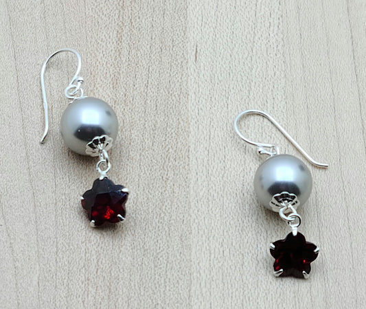 These crystal pearl & CZ earrings feature large 'flower' CZs in a deep garnet red color & are suspended from sterling silver fish hook ear wires.