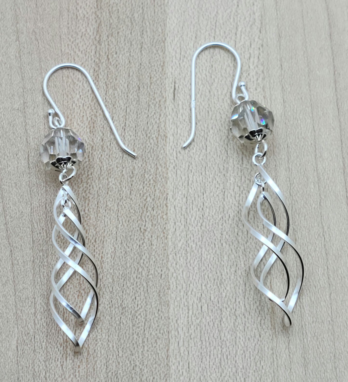 a large silver shadow crystal hosts double sterling silver spirals & the combo dangles from sterling silver fish hook ear wires. Very chic!