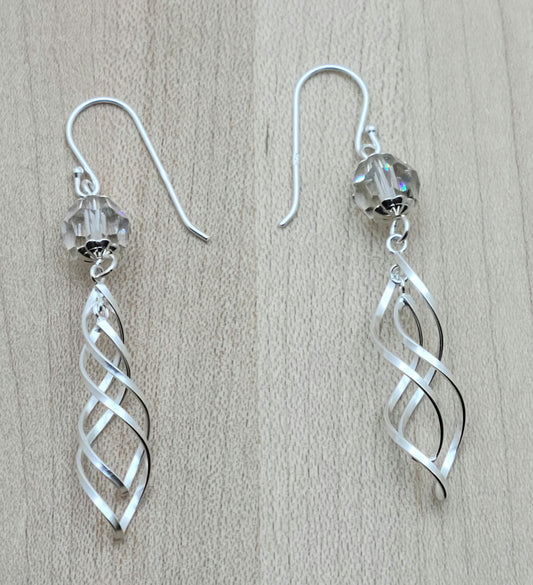 a large silver shadow crystal hosts double sterling silver spirals & the combo dangles from sterling silver fish hook ear wires. Very chic!