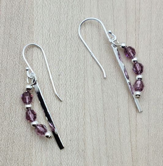a sterling silver thin blade and a curve of iris (light purple) crystals make for a  cute & interesting earring set. they hang from sterling silver fish hook ear wires.