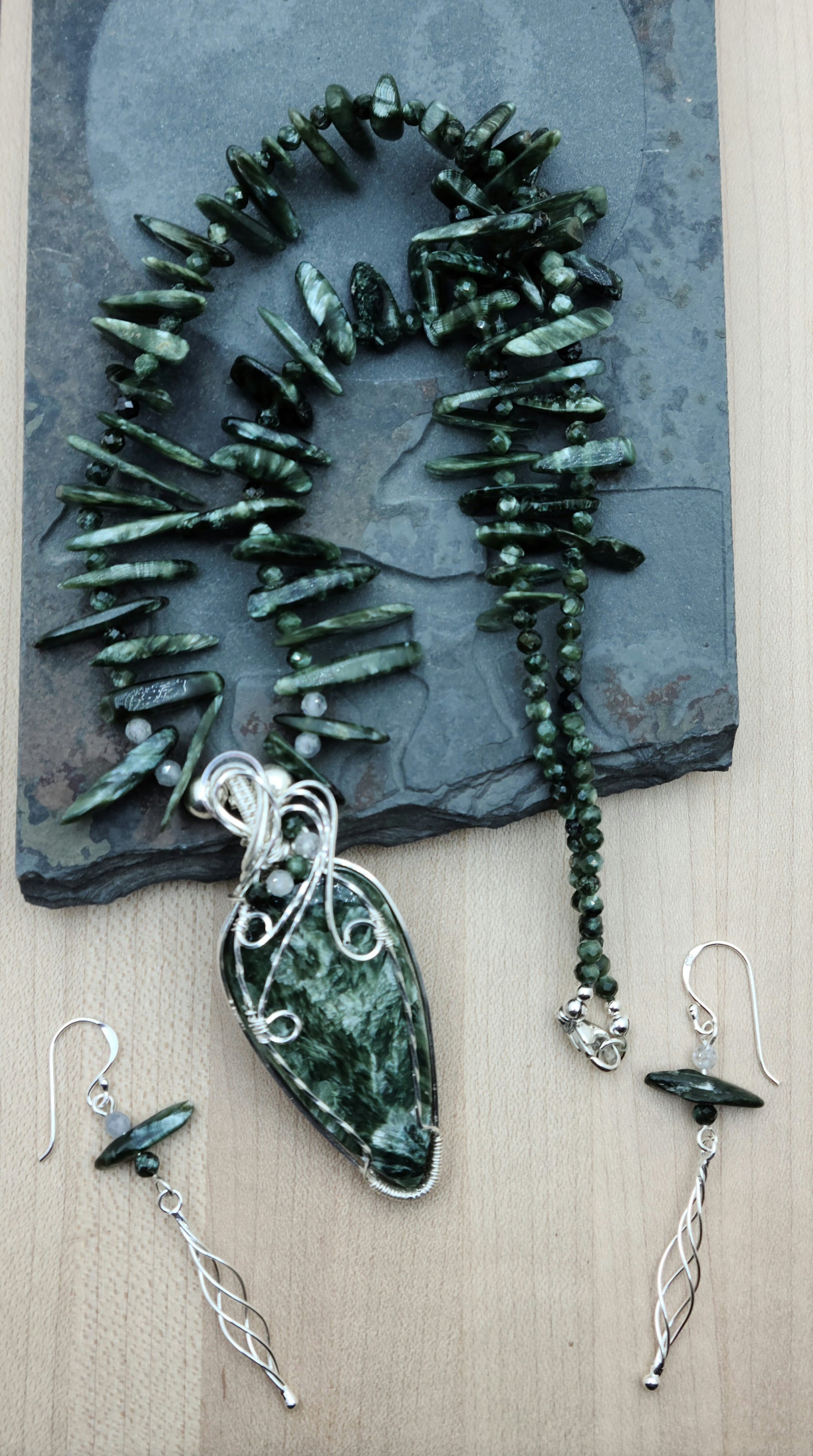 a seraphinite cabochon is framed in woven silver filled wire and hangs from necklace of seraphinte freeform spikes The earrings feature seraphinite & sterling silver.