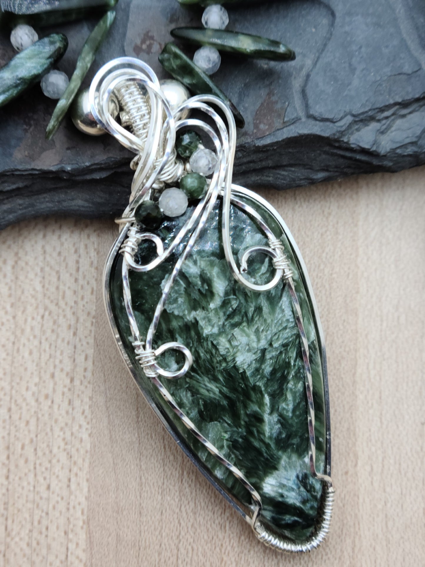 a seraphinite cabochon is framed in woven silver filled wire