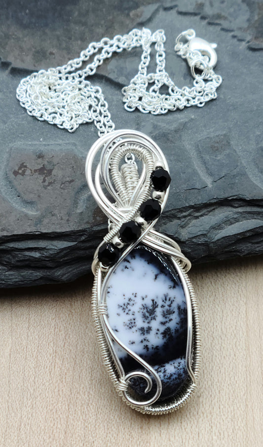 This fascinating dendrite stone has a scenic look to it. I framed it with woven silver filled wire and adorned it with tiny crystals