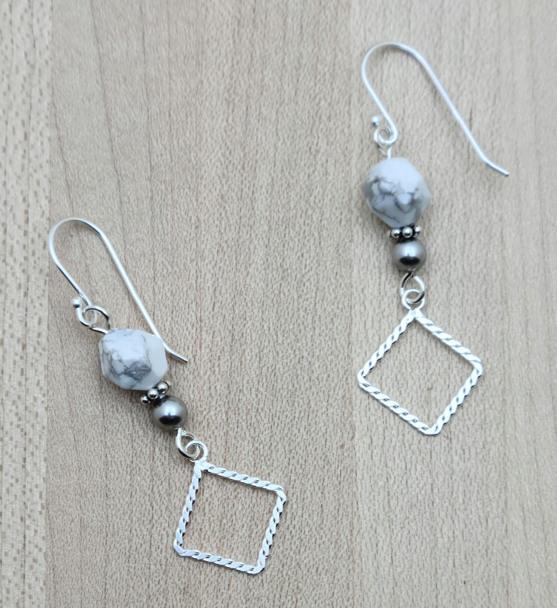 Faceted white & grey howlite & crystal pearls host angled sterling silver square donuts. Sterling silver fish hook ear wires.