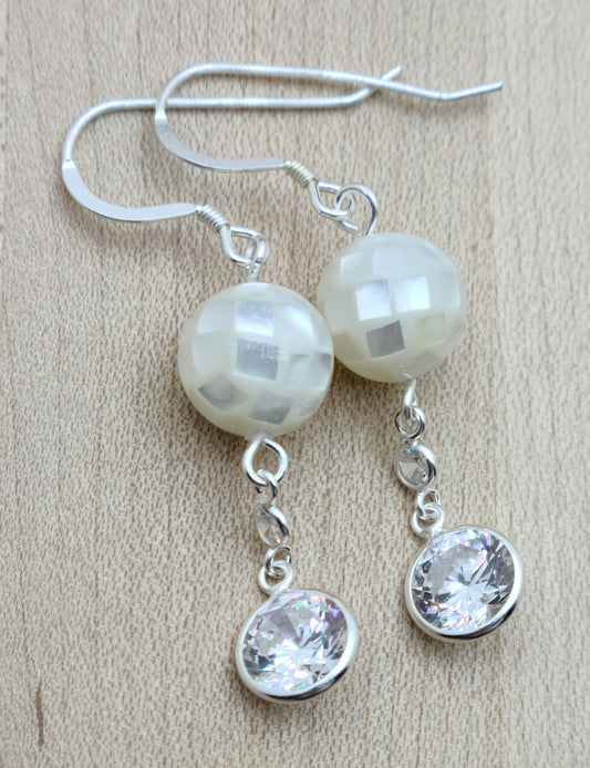 Sparkling cubic zirconia disks dangle attractively from mosaic mother of pearl beads, sterling silver fish hook ear wires