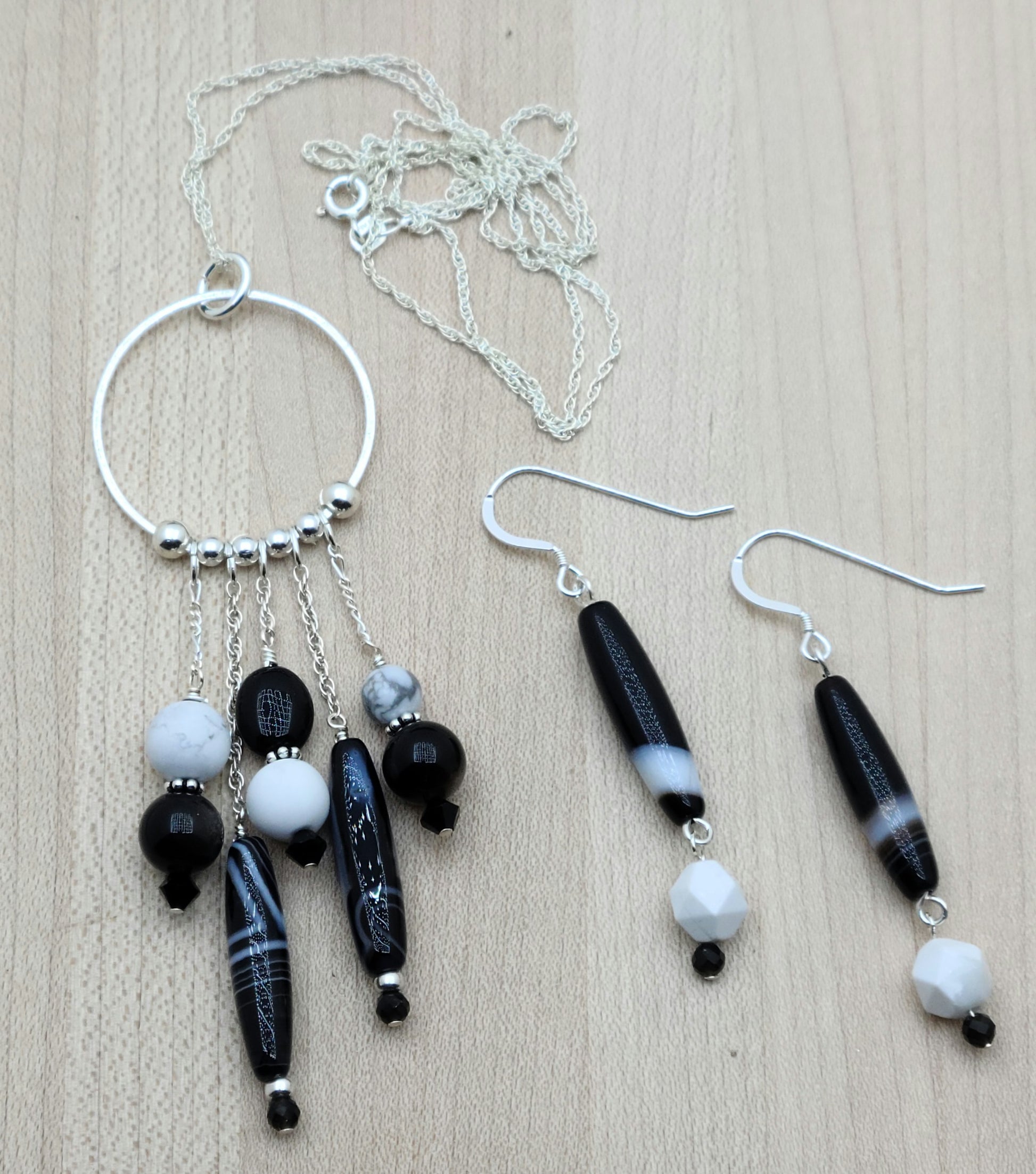 You'll love this eclectic collection of black and white stones and crystals, which dangle casually from a sterling silver hoop. Black & white is a classic combination and will go with almost anything in your wardrobe!