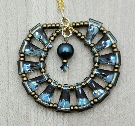 A gorgeous 'medallion' of blue back by bronze keyhole crystals circle up for a unique and flashy pedant!