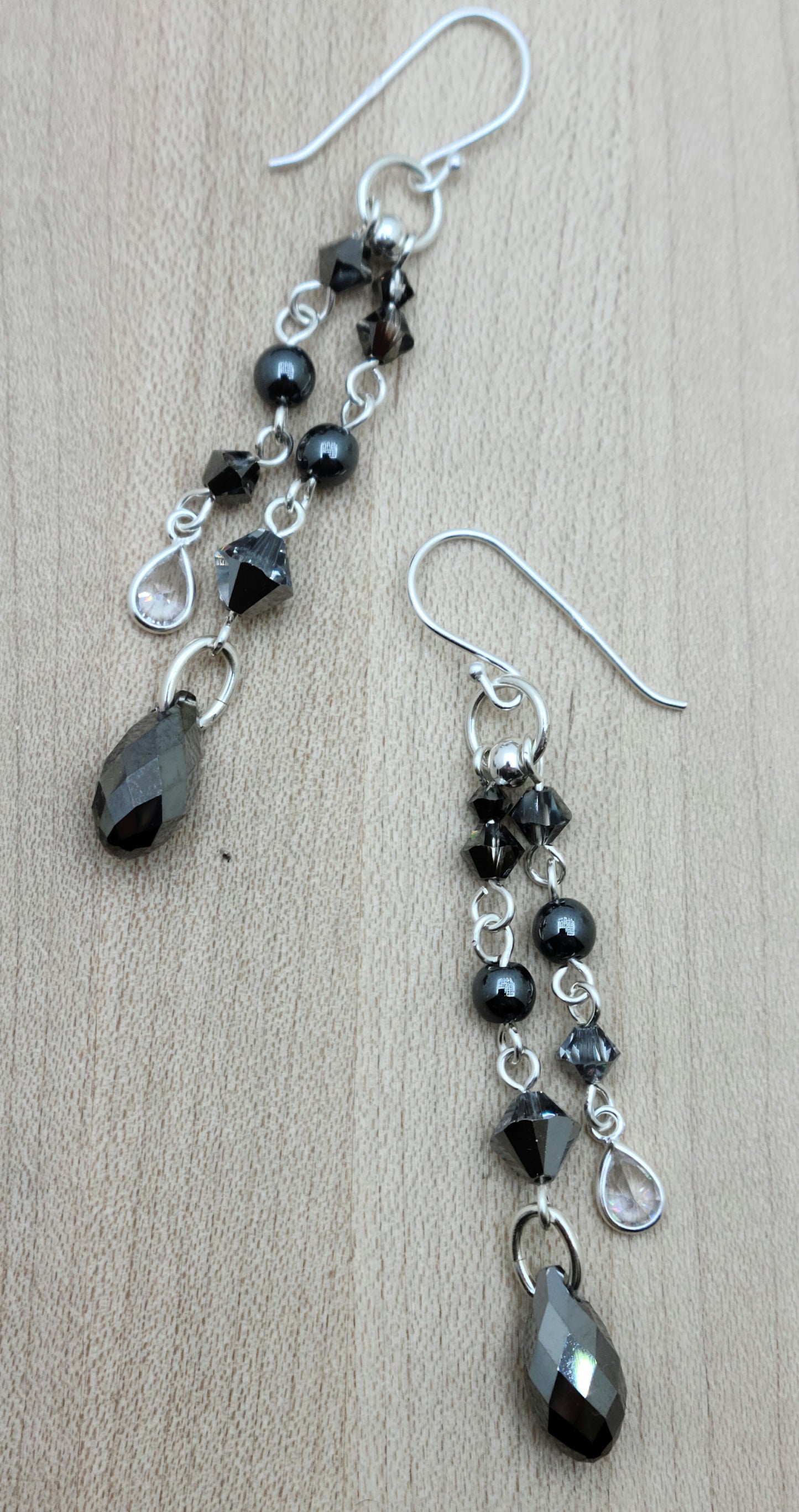 A dramatic look without bulk or weight! A combination of hematite, cubic zirconia, and various shades of black crystals cascade in a double row with LOTS of movement! Sterling silver fish hook earrings