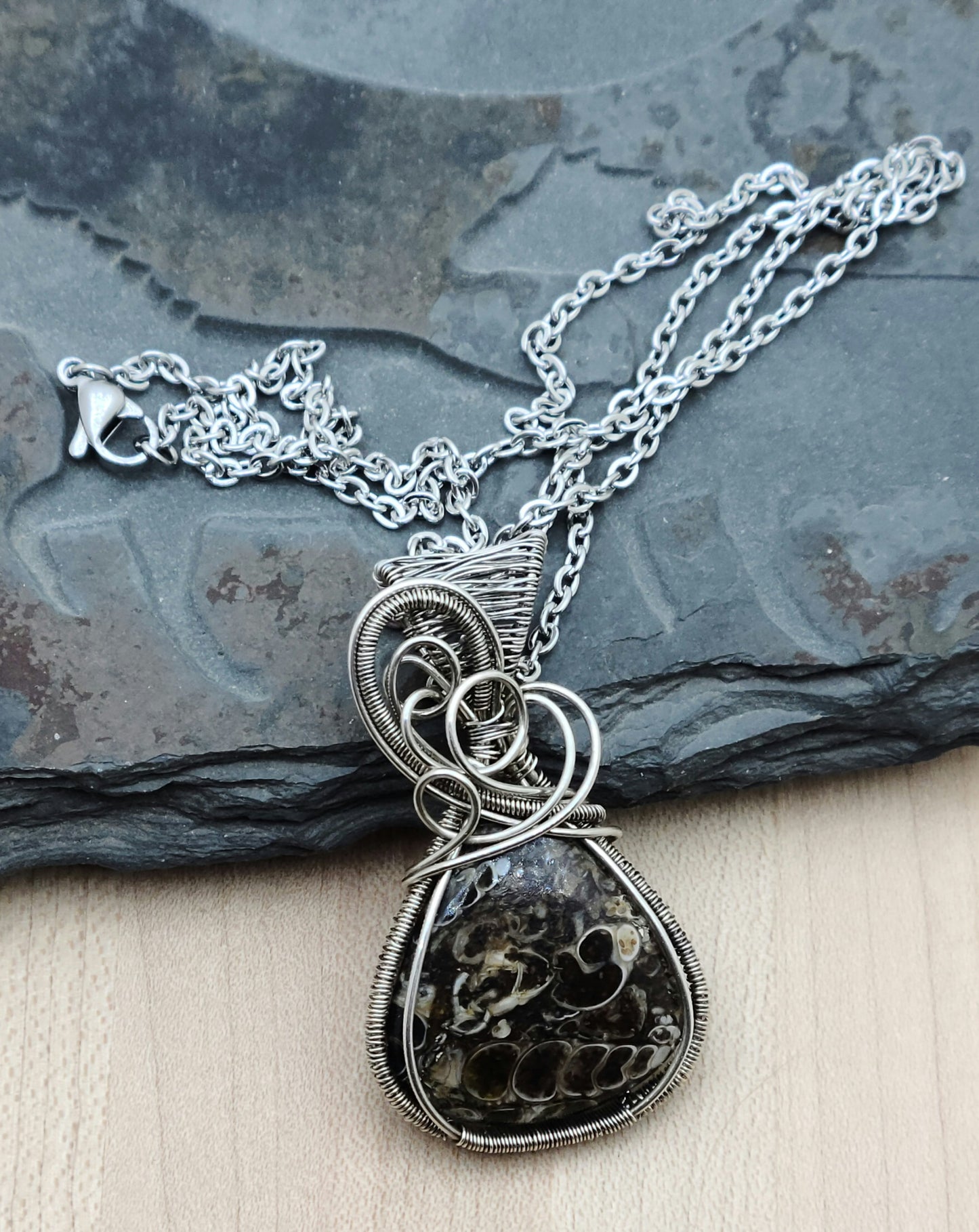 A grounding stone, this fascinating turitella agate pendant is framed with woven, antiqued sterling silver filled wire.