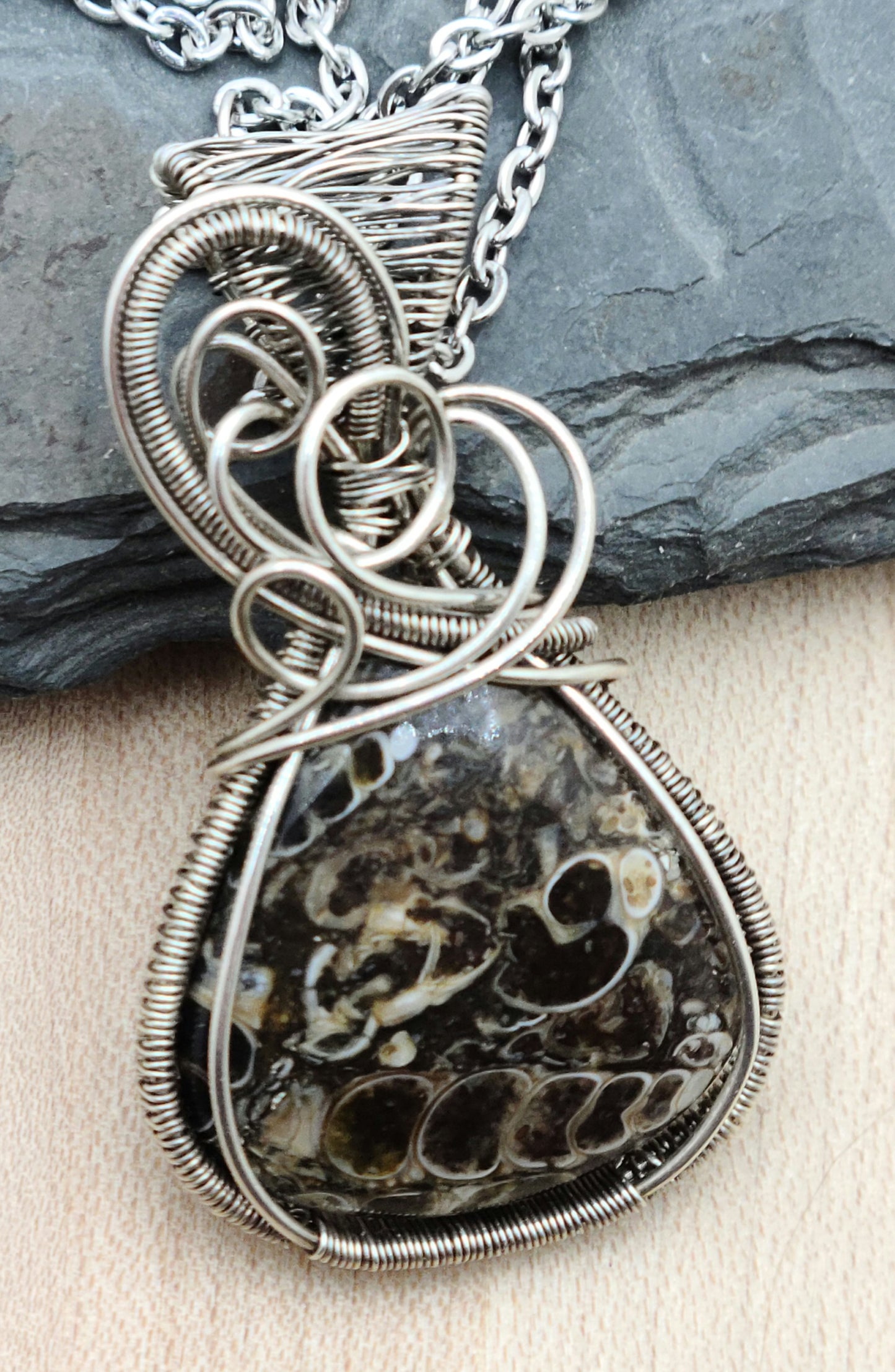 A grounding stone, this fascinating turitella agate pendant is framed with woven, antiqued sterling silver filled wire.