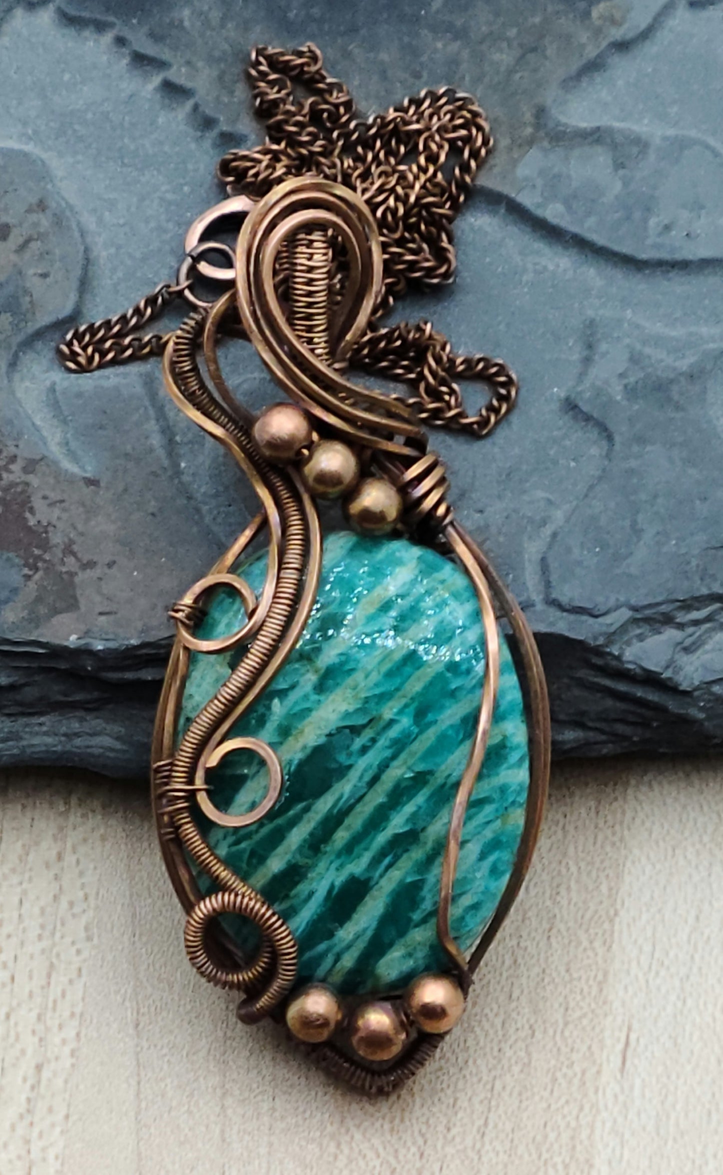 This striated amazonite pendant is framed with antiqued copper wire.