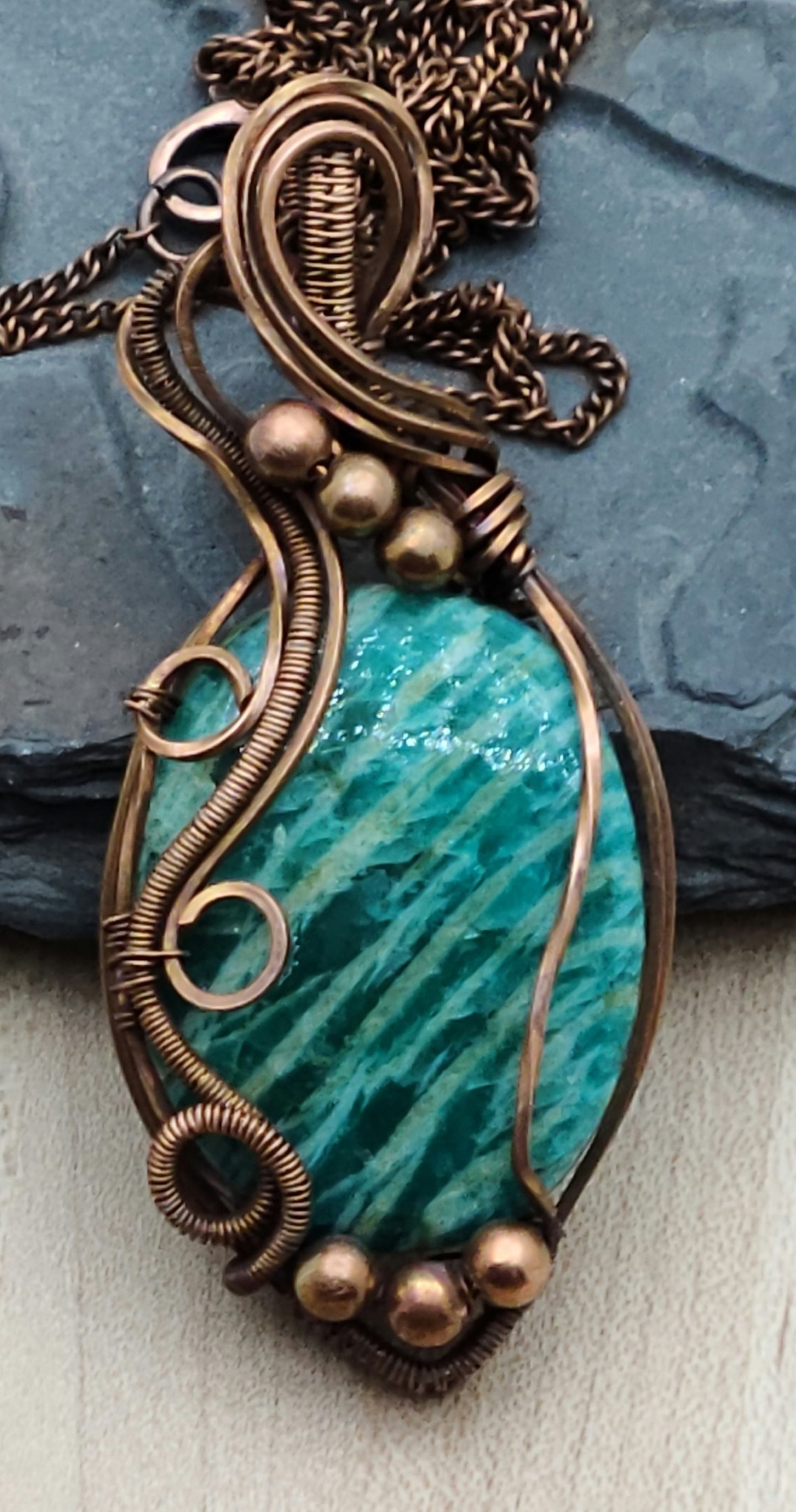 This striated amazonite pendant is framed with antiqued copper wire.