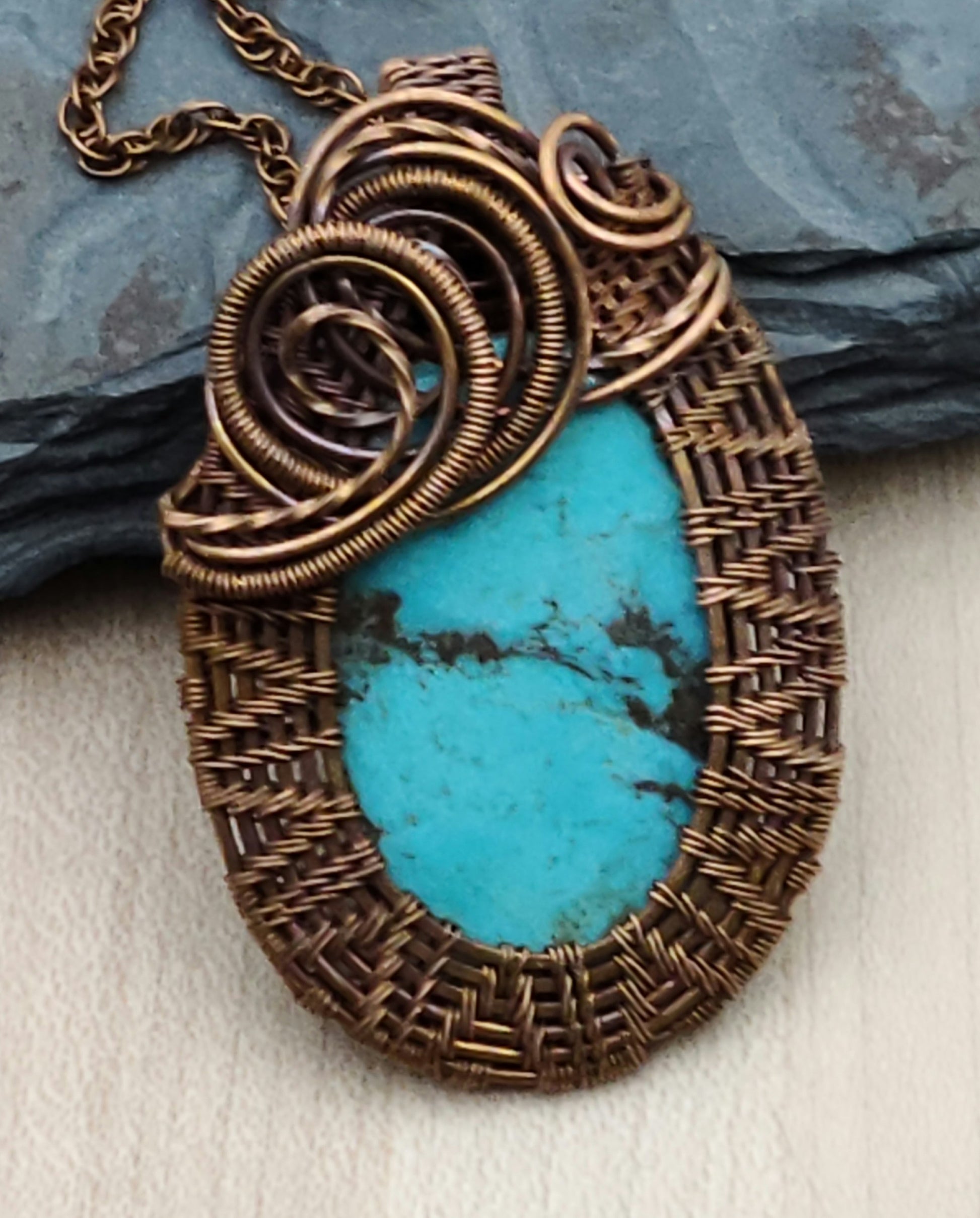 Chevrons & swirls of copper wire surround the lovely turquoise cabochon pendant.