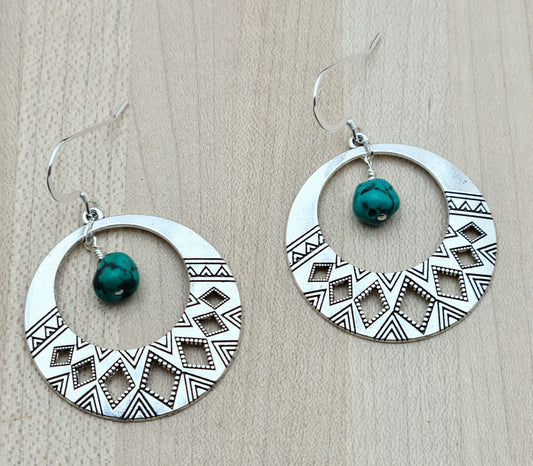 Tribal designed hoops host real Turquoise nuggets in these Earrings with sterling silver fish hook earwires.