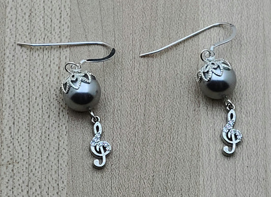 Sparkle with your love of music! Sterling silver & cubic zirconia treble clefs catch the light, as do the bead caps on the silver crystal pearls from which they are suspended!
Lovely & lightweight!