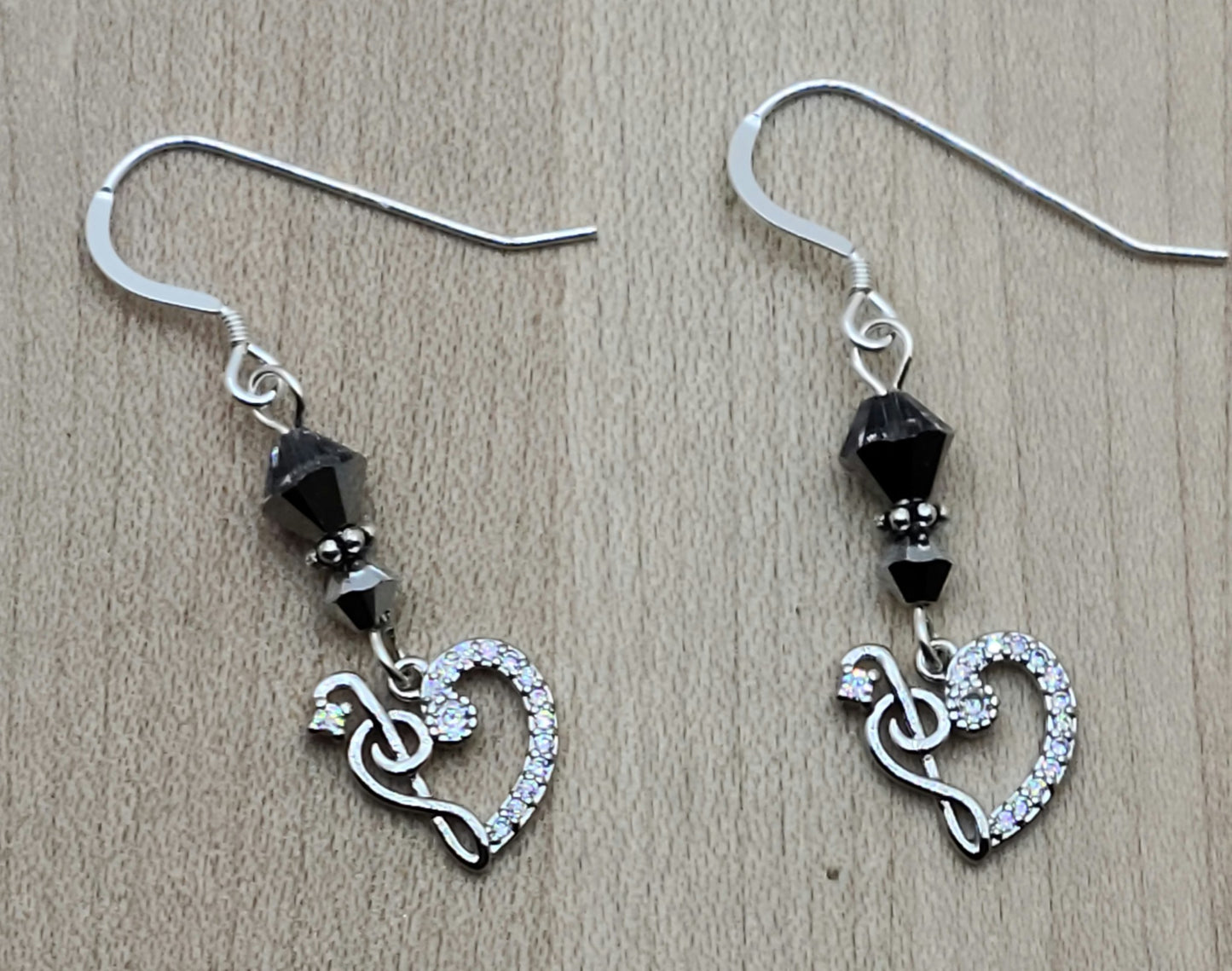 Sparkle with your love of music! Sterling silver & cubic zirconia treble clefs and bass clefs join to form a delightful heart & catch the light, as do the the crystals from which they are suspended!
