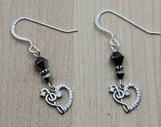 Sparkle with your love of music! Sterling silver & cubic zirconia treble clefs and bass clefs join to form a delightful heart & catch the light, as do the the crystals from which they are suspended!