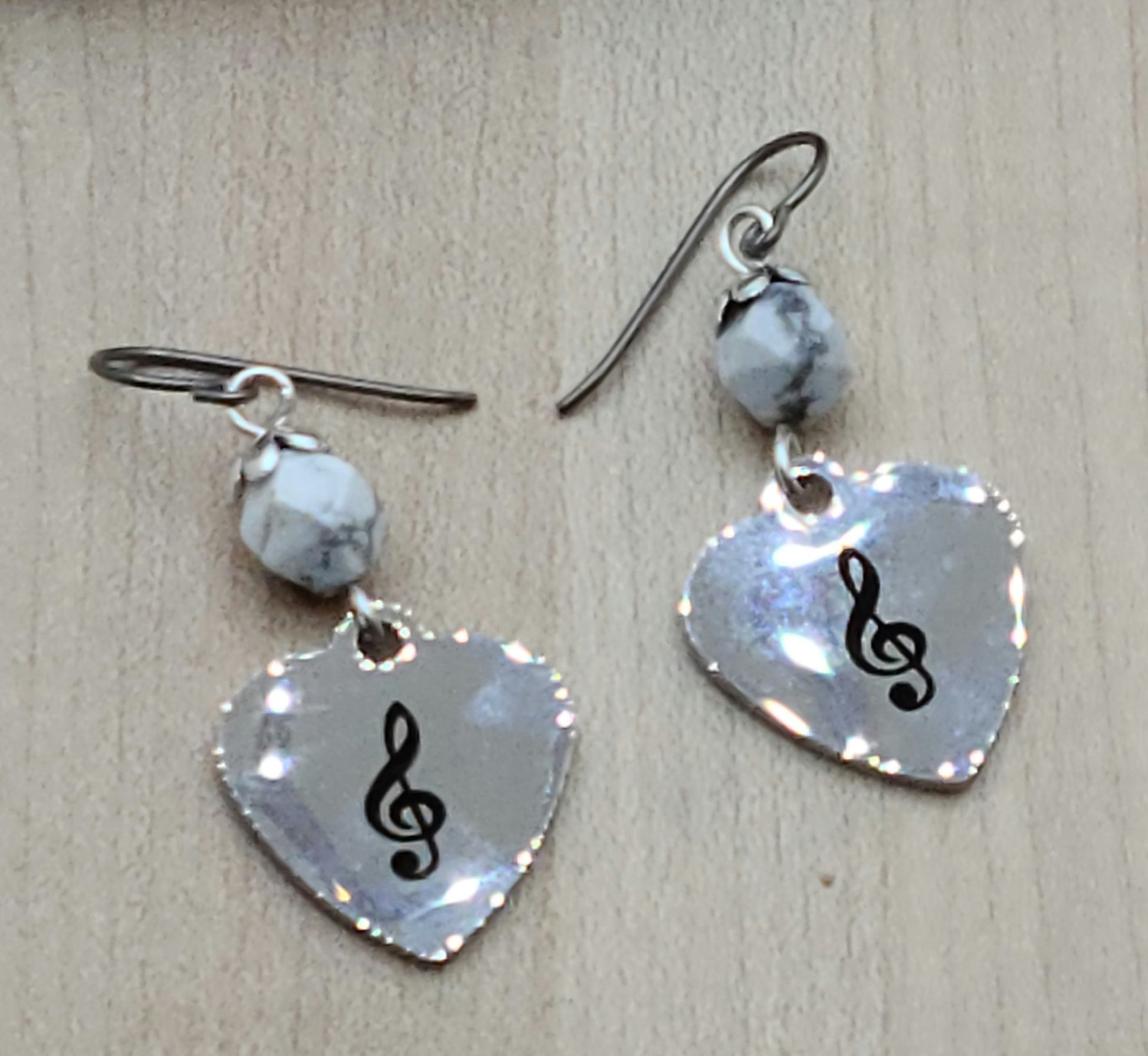 Love music? Play a treble clef instrument? Then these stainless steel hearts displaying a treble clef are for you! For added interest they hang from capped, faceted howlite beads.