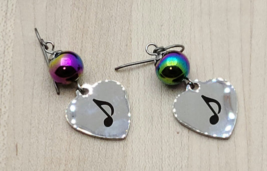 Love music? Play a group? Then these stainless steel hearts displaying an 8th note are for you! For added interest they hang from hematite beads electroplated in rainbow colors!
1 3/4" with niobium (considered hypoallergenic) fish hook earwires