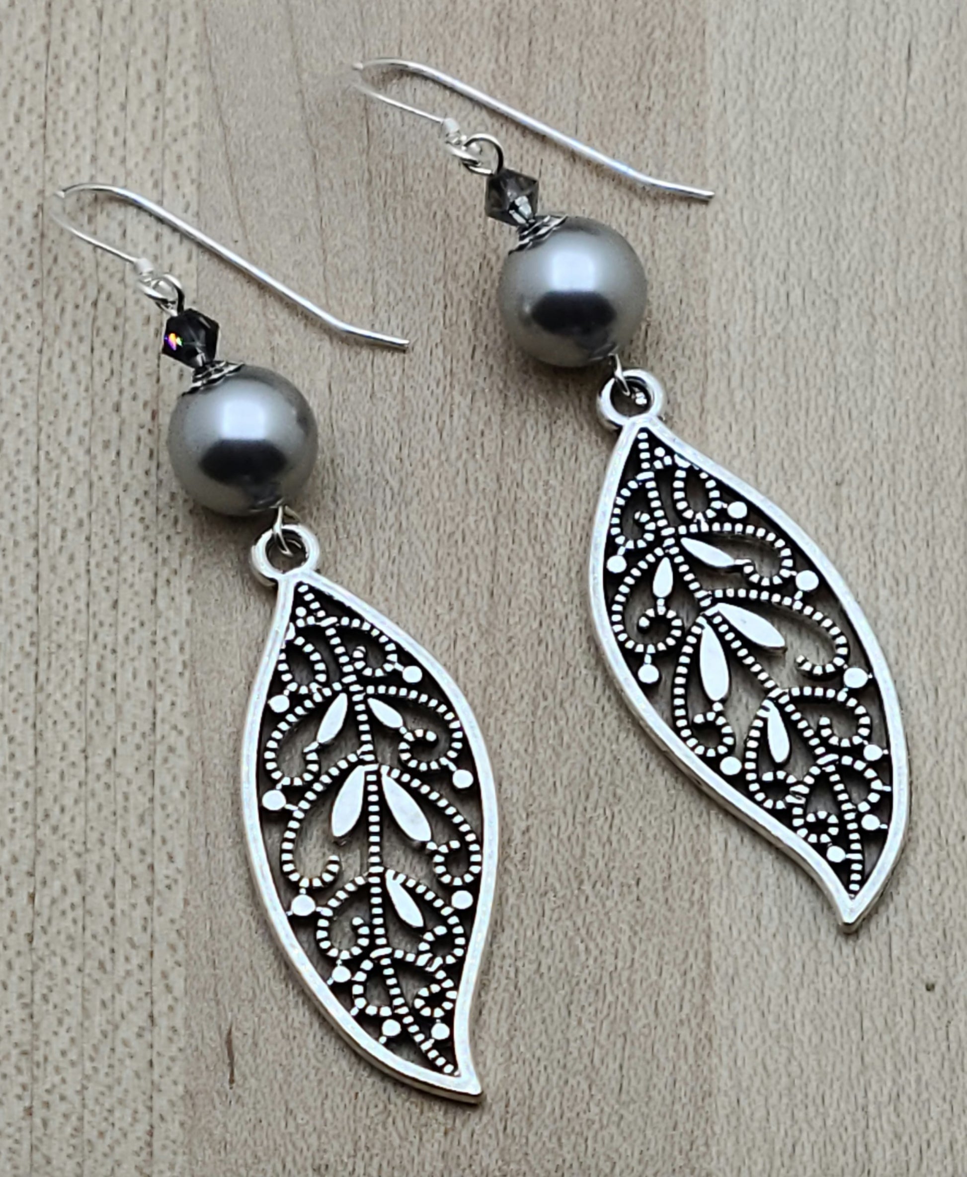 Intricate open work leaves in pewter and lustrous silver crystals & crystal pearls combine for elegant & fancy earrings that will complement any outfit!