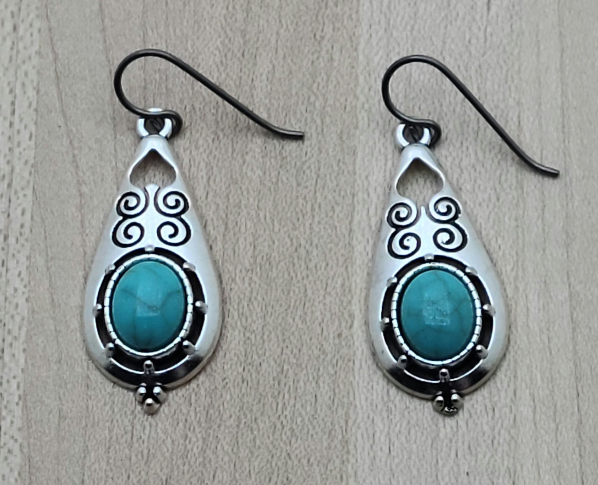 These stamped, lead-free pewter earrings are adorned with turquoise howlite and are extremely lightweight. A great look without the weight! niobium (hypoallergenic) fish hook ear wires